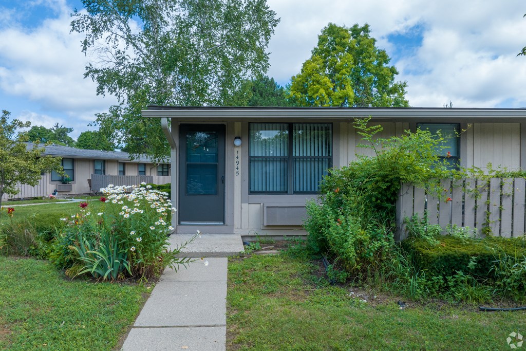 a house with a blue door and a sidewalk in front of it