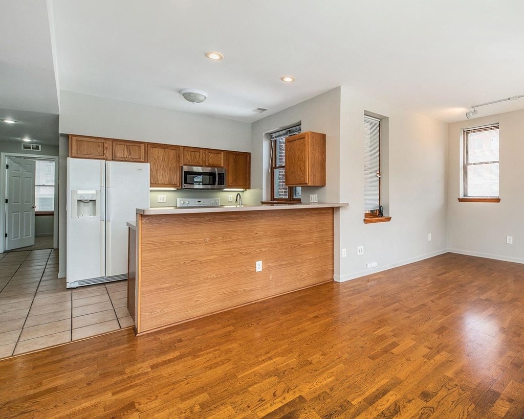 a kitchen and living room with wood floors and white walls