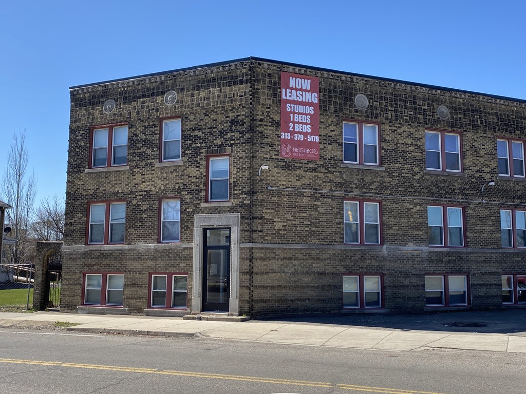 an old brick building with a red sign on the side of it