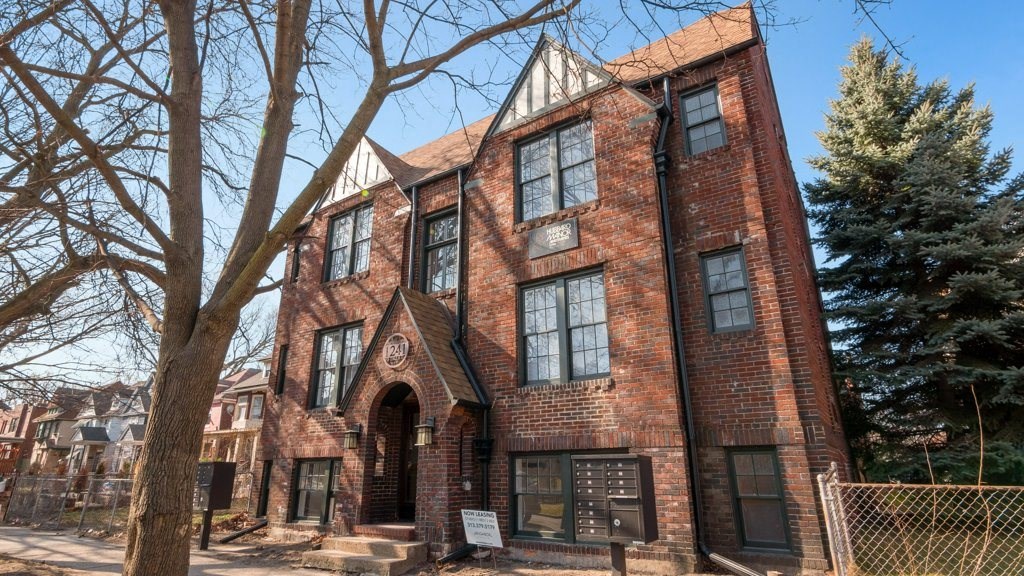 a large brick building with a tree in front of it