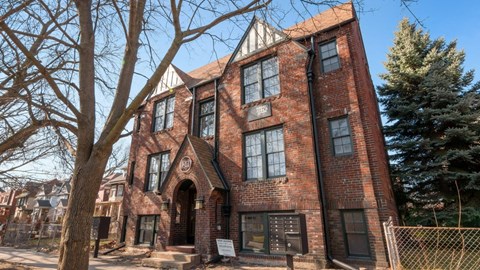 a large brick building with a tree in front of it