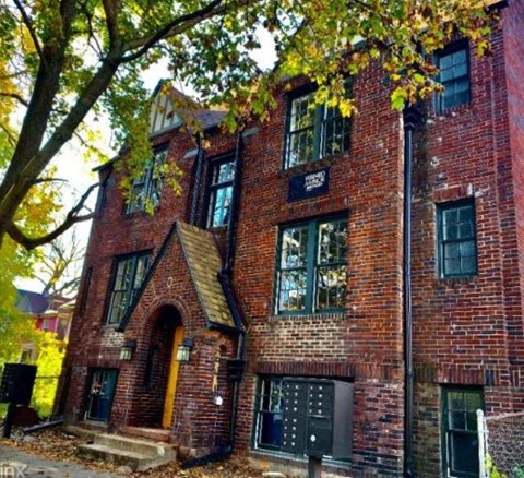 a brick building with a tree in front of it