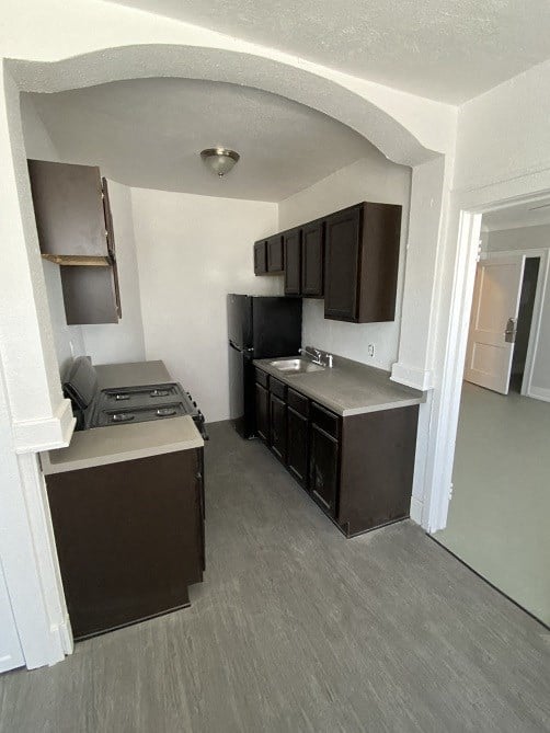 a kitchen with a stove and a sink and a refrigerator