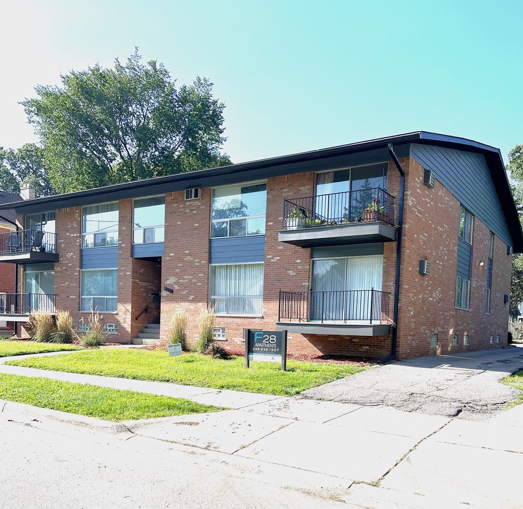 a brick apartment building with a sidewalk in front of it