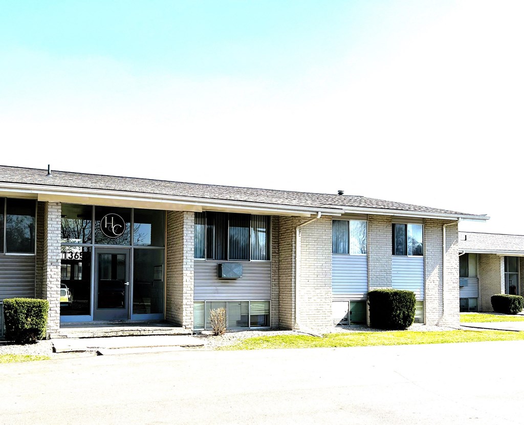 the front of a white building with a black door