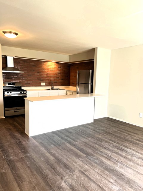 a kitchen with a counter and a stove and a refrigerator