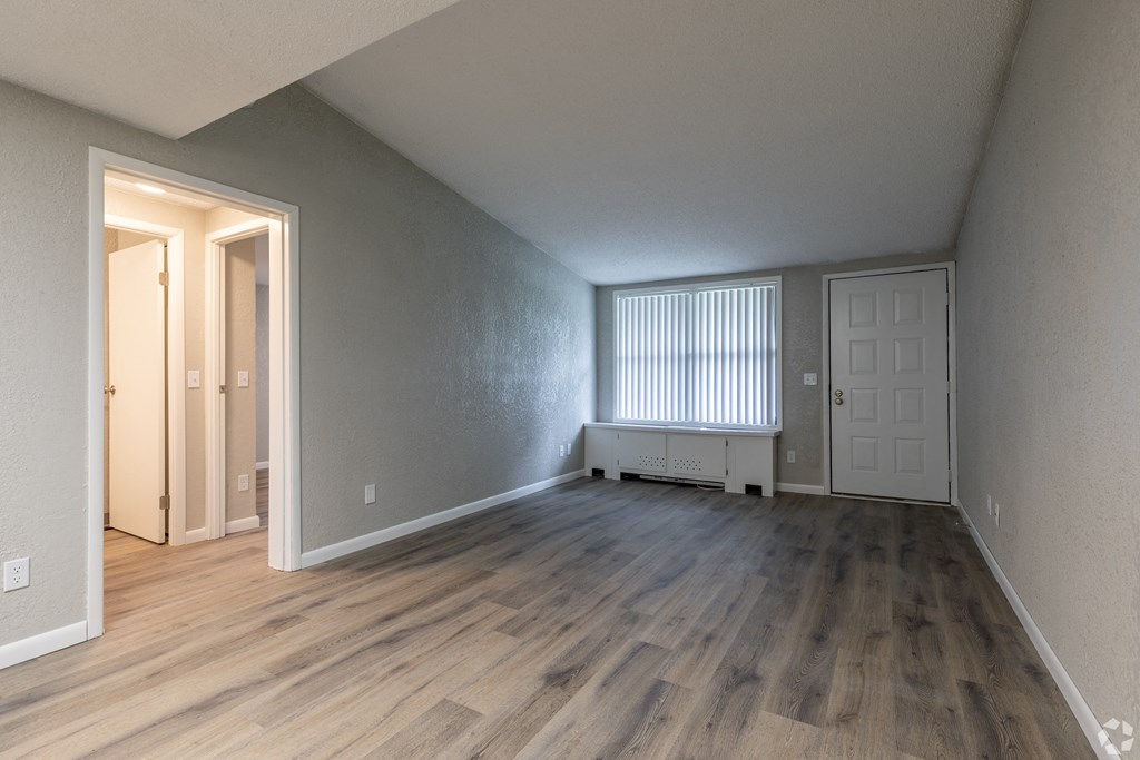 the living room of an empty apartment with wood flooring