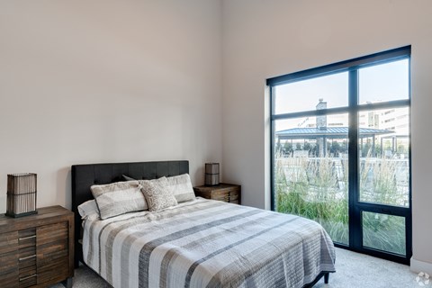 a bedroom with a bed and a large window