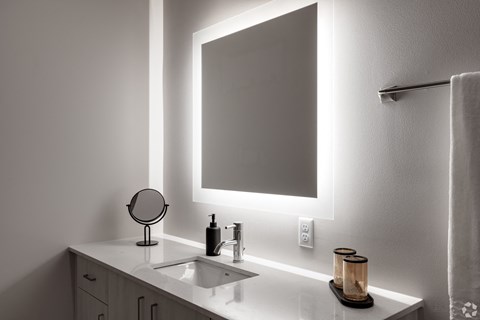 a bathroom with a mirror and a sink and a towel rack