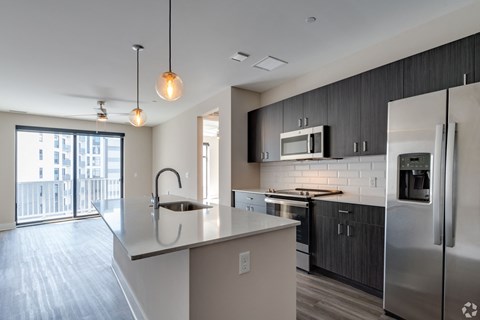 a kitchen with a large island and stainless steel appliances