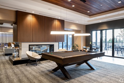a living room with a pool table and a fireplace