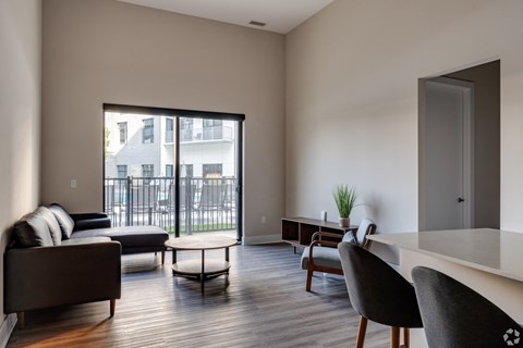 a living room with a couch and a table and a balcony