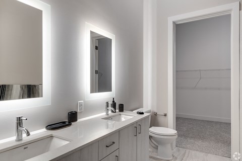 a white bathroom with two sinks and a toilet