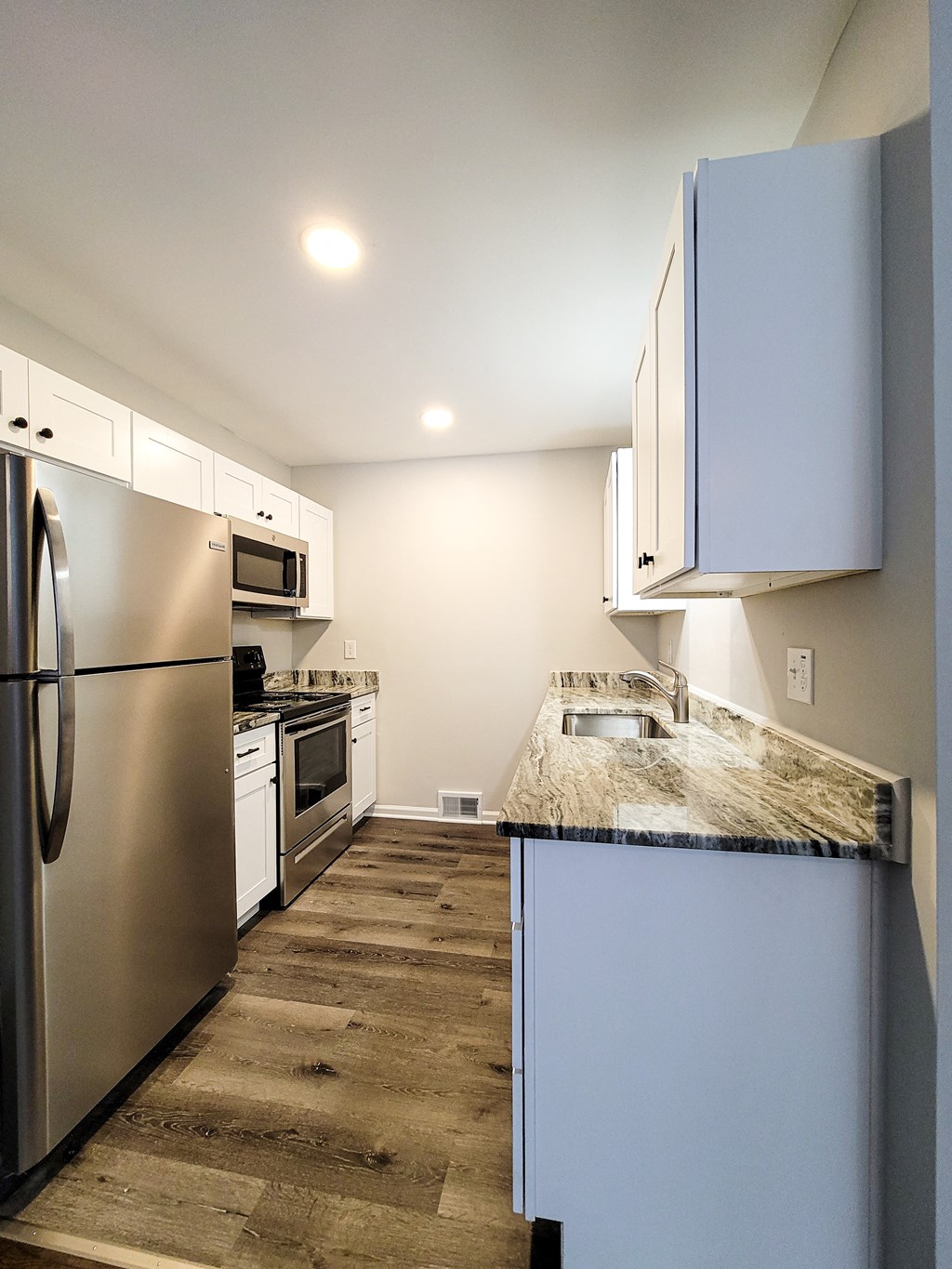 a kitchen with stainless steel appliances and a marble counter top