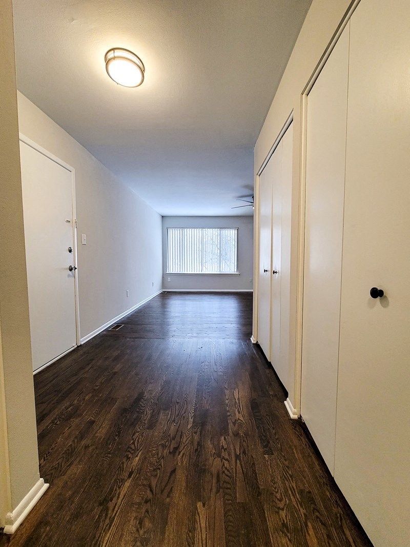 an empty living room with wood floors and white closets