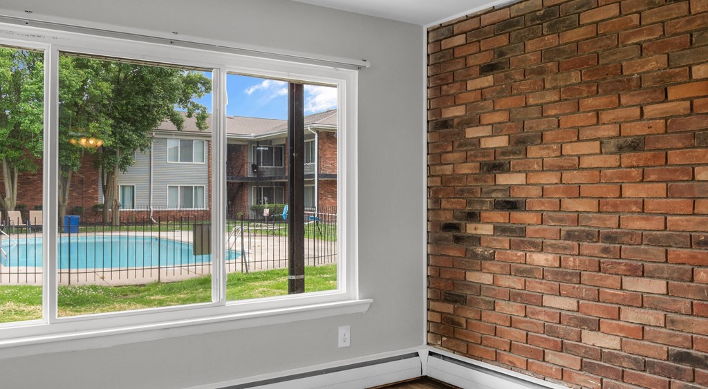 A room with a brick wall and a sliding glass door.