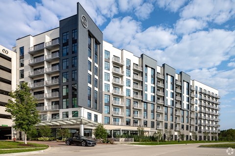 a large apartment building with a car parked in front of it