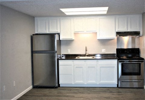 A kitchen with white cabinets and stainless steel appliances.