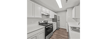 a kitchen with white cabinets and a stove and a sink