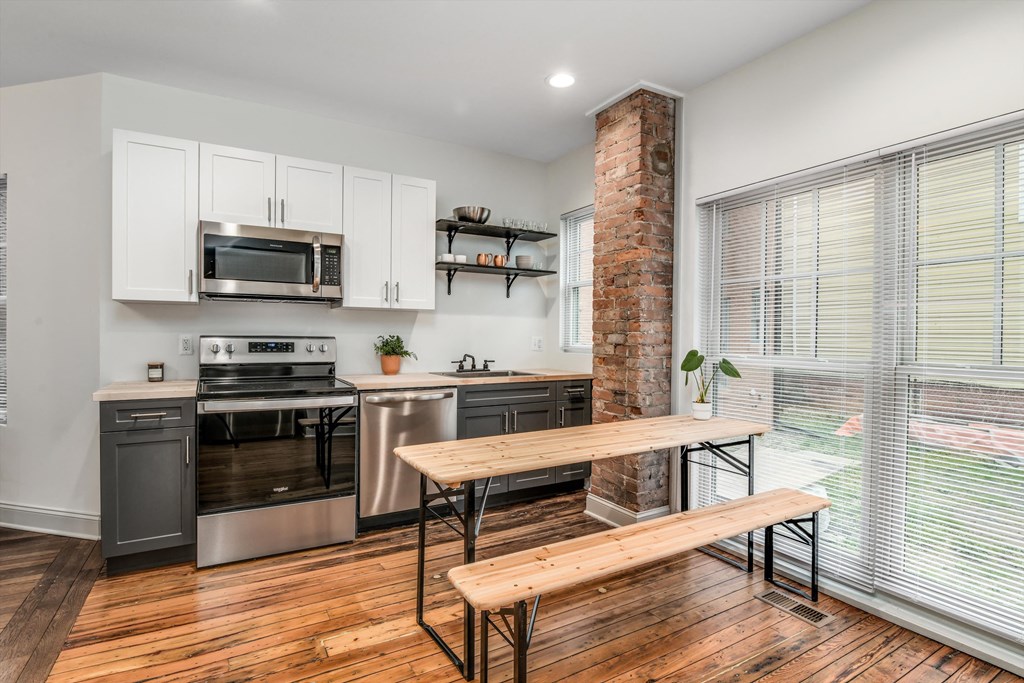A kitchen with a wooden table and bench seating.