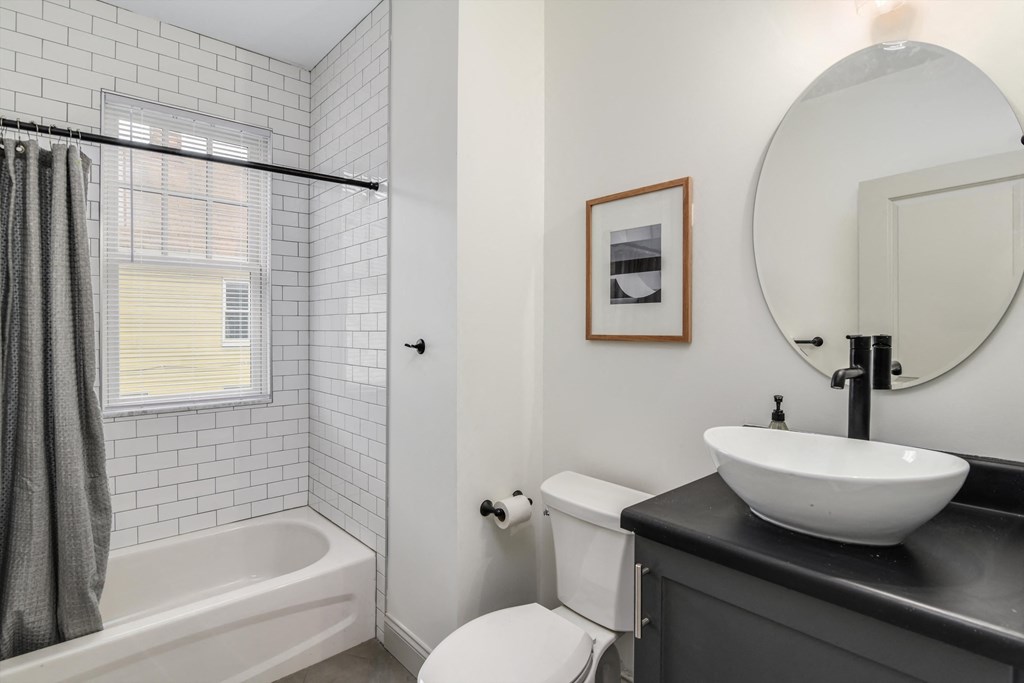 A bathroom with a white tub, toilet, and sink.