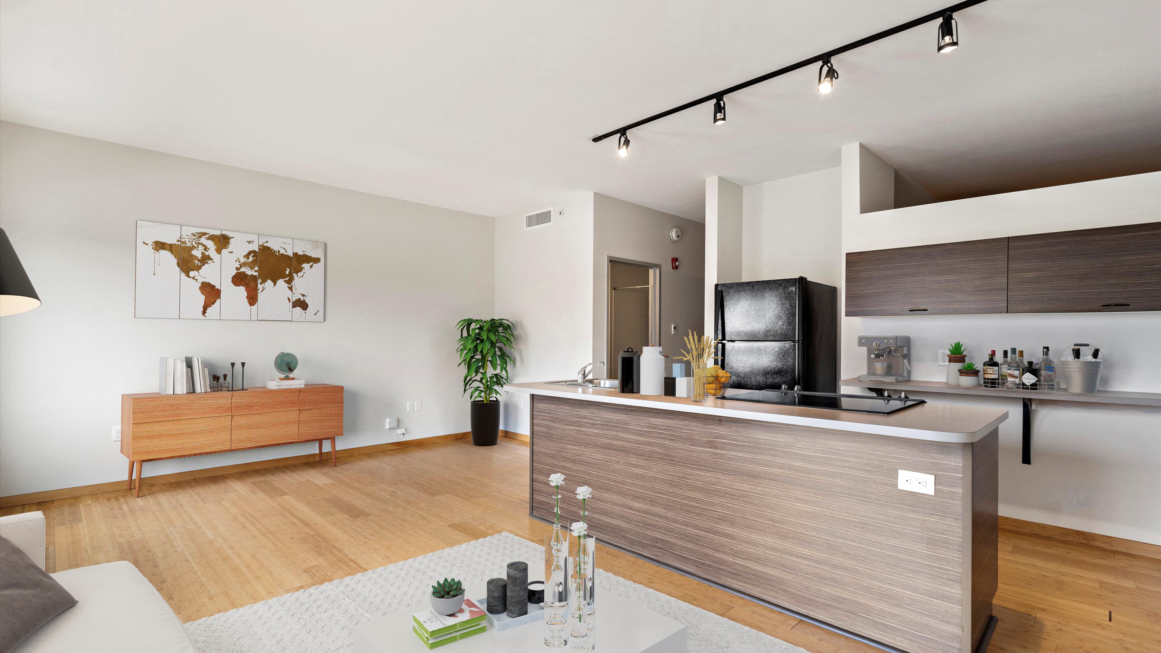 a kitchen and living room with white walls and hardwood floors