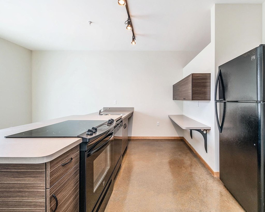 a kitchen with white walls and black appliances