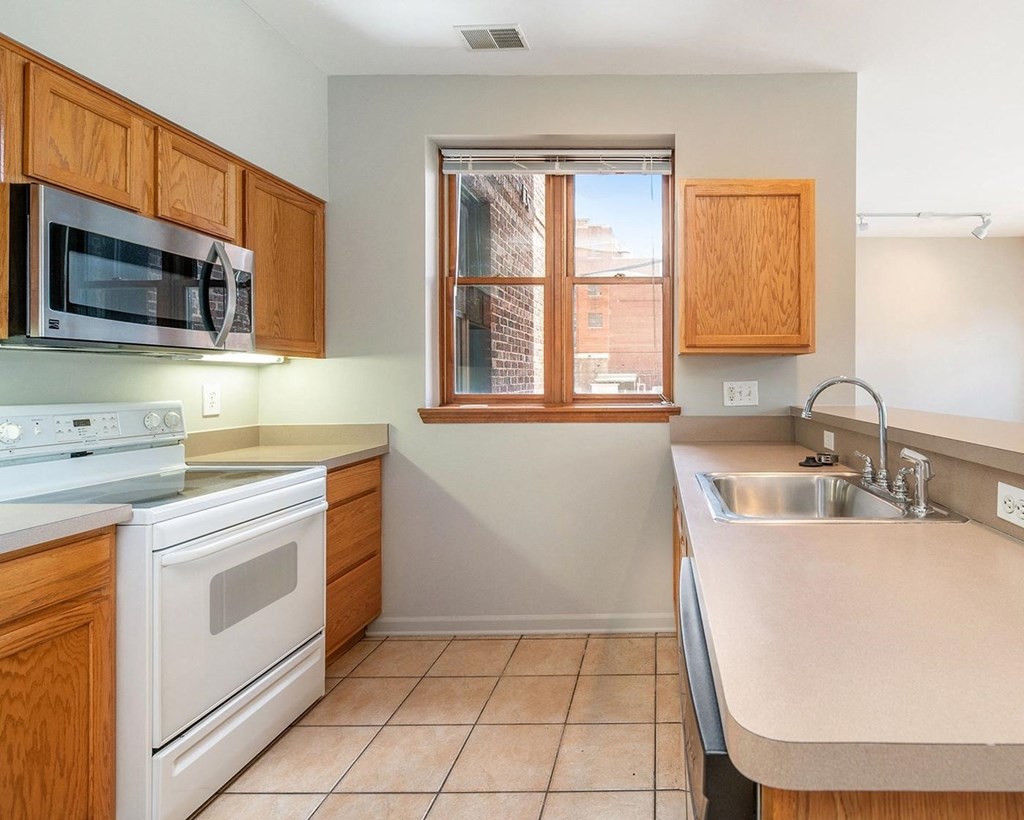 a kitchen with white appliances and wooden cabinets