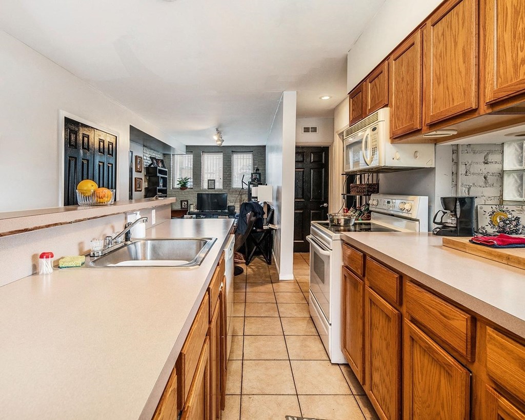 a kitchen with wooden cabinets and white appliances