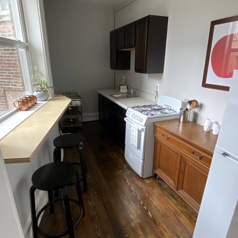 a kitchen with a stove and a counter with stools