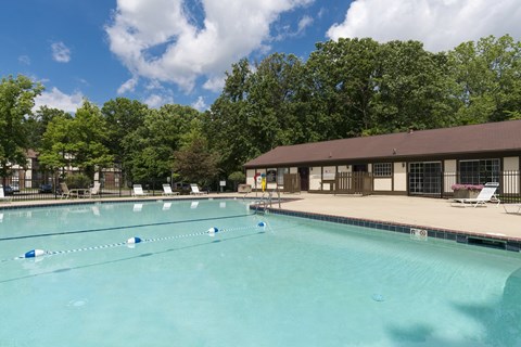 A large swimming pool with blue lane markers and a building in the background.
