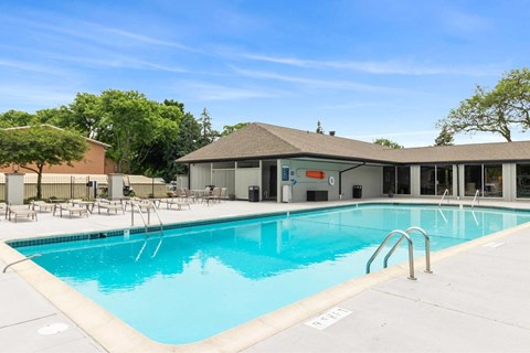 A large swimming pool with a building in the background.