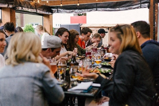 a group of people sitting around a table eating food