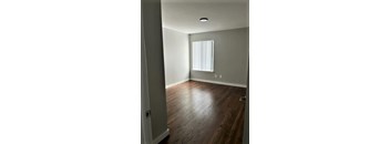 A room with a window and wooden floors.