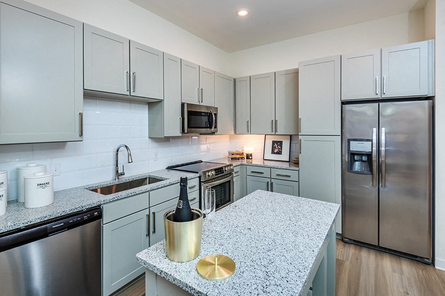 Kitchens include stainless steel appliances and 42'' white or gray shaker-style cabinets