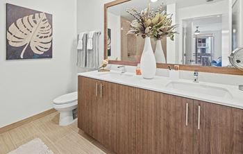 A bathroom with a toilet, sink, and mirror.