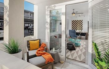 A patio with a chair and a table with a blanket on it.