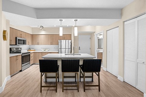 a kitchen with a large island with black chairs