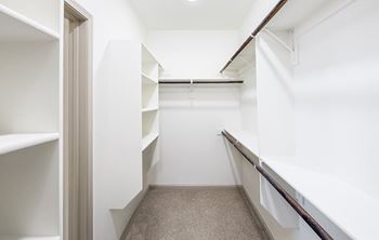 A white hallway with a carpeted floor and white walls.