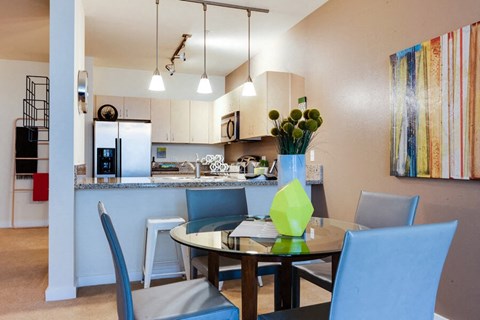 A modern kitchen with a dining table set for four.