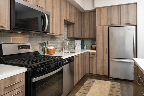 A modern kitchen with a black stove top oven and a white refrigerator.