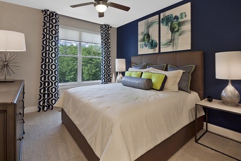 A bedroom with a large bed and a ceiling fan.