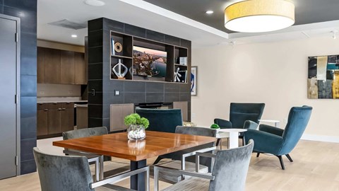 A modern dining room with a wooden table and grey chairs.