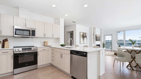 A modern kitchen with a black oven and white cabinets.
