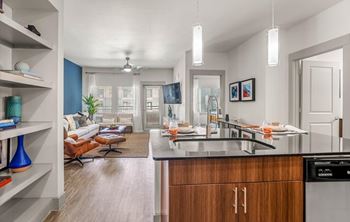 A modern kitchen with a dining area and a living room.