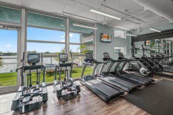 A gym with treadmills, elliptical machines, and other exercise equipment.