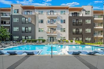 A large apartment complex with a pool in the middle.