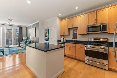 A kitchen with wooden cabinets and a black countertop.