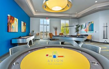 A yellow table with the words "AVION ON LEGACY" on it is in the center of a room with blue walls.