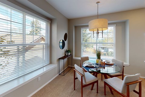 A dining room with a round table and chairs.
